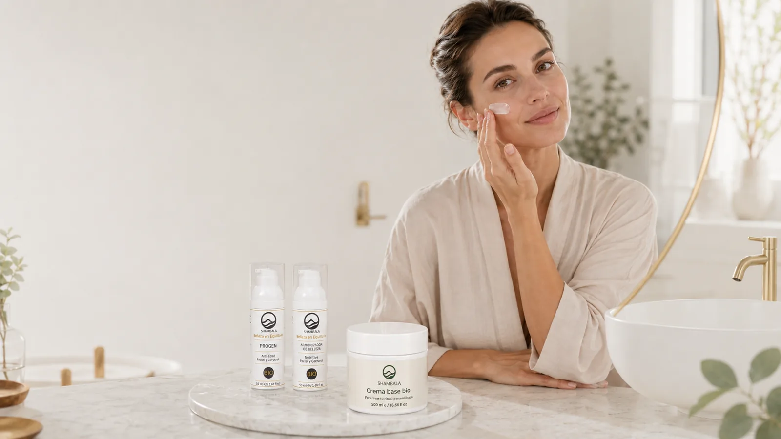 Mujer aplicando crema facial junto a productos de Cosmética Shambala en un baño luminoso